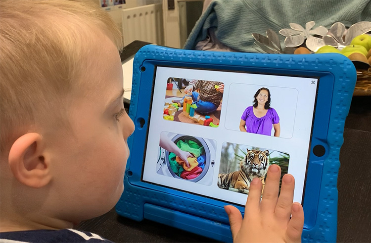 A photograph of a child learning new vocabulary by selecting pictures in an app.