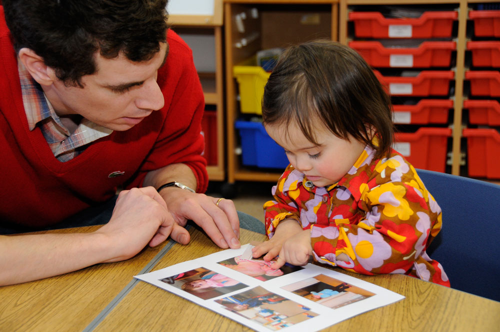 Photograph of a child with Down syndrome learning early vocabulary by matching pictures